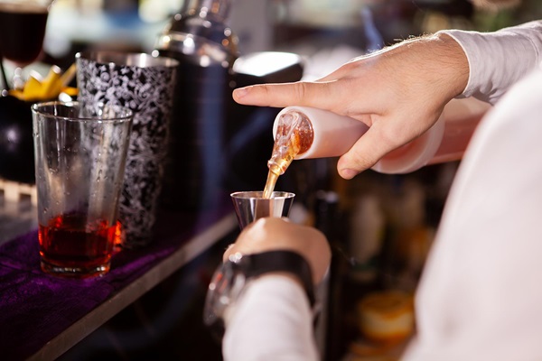 Bartender pouring liquor into a jigger_measure.